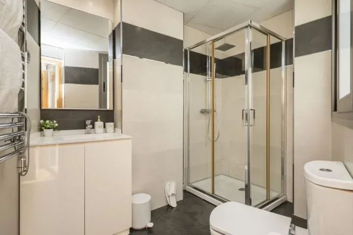 Salle de bain avec miroir sans cadre, lavabo avec meuble en bois laqué blanc